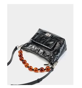Vue détaillée du sac vintage en cuir ciré noir avec perles d'ambre et fermoir argenté
