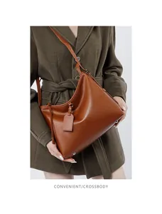 Macro view of brown genuine leather tote with silver metal studs and adjustable strap