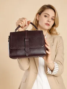 Detail of burgundy leather handbag showing protective metal feet and premium texture