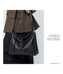 Detail of black leather hobo bag with bottom metal feet and stylish leather tag