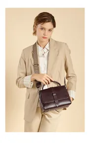 Detail of genuine leather handbag with vintage buckle and ethnic style woven strap