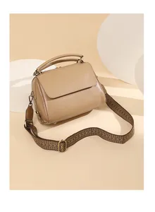 Detail der beigen Echtleder-Boston-Tasche mit einem gewebten Chevron-Schultergurt