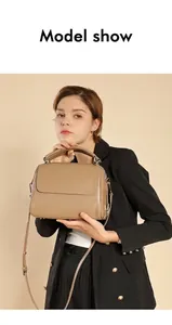 Model trägt eine große Boston-Handtasche aus erdfarbenem Leder für den Büro- und Berufsalltag