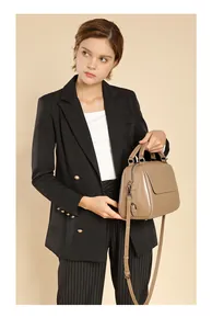 Detail einer Retro-Arzttasche aus Leder in Khaki mit abnehmbarem Schultergurt und Griffen