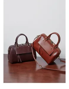 Detail view of leather Boston bags with vintage gold hardware and decorative tassels