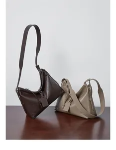 Close-up of vintage leather tote bags showing natural grain and wide shoulder straps