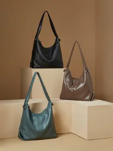 Three minimalist leather hobo tote bags in black, brown and dark green on display