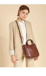 Borsa a secchiello in vera pelle marrone con blazer beige per un look da ufficio