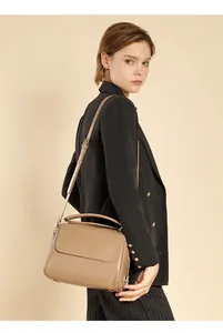 Schicke beige Handtasche aus Rindsleder mit verstellbarem Riemen an einem professionellen Model