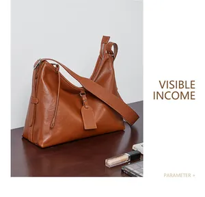 Detail of vintage brown leather hobo bag showing oily texture and tassel zip puller