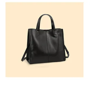 Detailed view of large black leather tote bag with vertical stitching and shoulder strap
