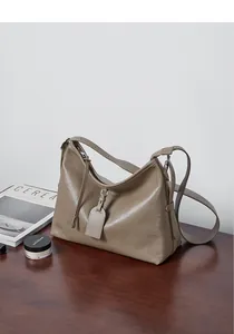 Detailed view of the taupe leather tote bag showing its soft texture and side tag detail