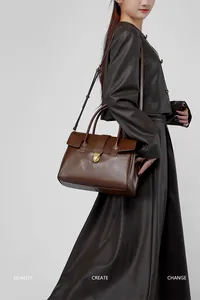 Dettaglio borsa tote in pelle vintage con fibbia dorata e tracolla regolabile