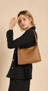 Detailaufnahme einer braunen Schultertasche aus genarbtem Leder mit Knotendetail