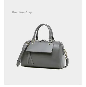 Detail shot of deep grey leather Boston bag with vintage hardware and tassels