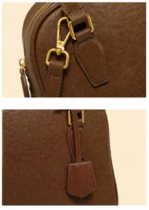 Dettaglio borsa in pelle marrone con finiture dorate e fibbia a tracolla rimovibile