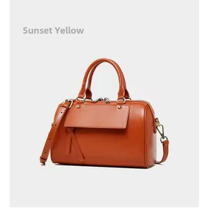 Detailed macro shot of the sunset yellow genuine leather Boston bag with metallic hardware