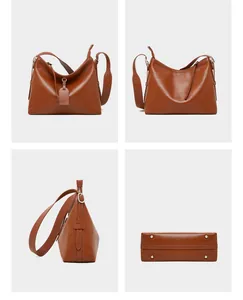 Detail view of brown leather tote showing texture, silver buckles and bottom rivets