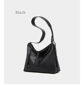 Detail of black pebbled leather tote bag featuring silver hardware and wide shoulder strap