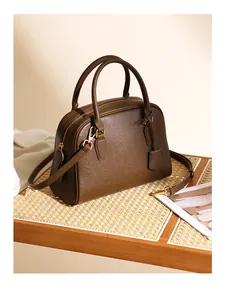Dettaglio borsa Boston in pelle marrone con finiture dorate e tracolla rimovibile