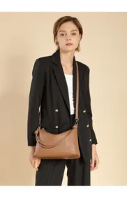 Braune Leder-Schultertasche mit Litschi-Struktur und Knotengriff-Detail am Modell