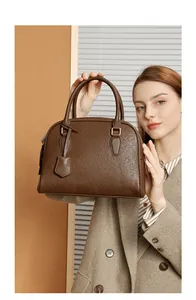 Dettaglio della borsa Boston in pelle martellata marrone scuro con finiture dorate