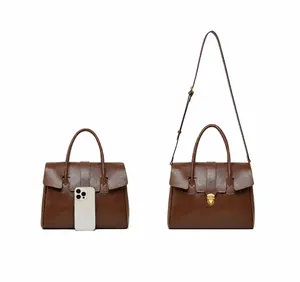 Detail view of large leather tote bag with dual straps and iPhone 16 Pro size comparison