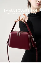 Close-up of wine red matte leather small square bag with silver hardware and double zippers
