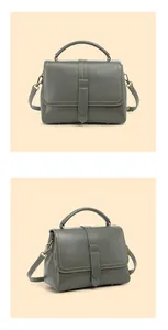 Detailed view of dark grey leather handbag with bronze hardware and reinforced top handle