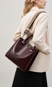 Borsa tote media in pelle bordeaux con tracolla jacquard indossata da una modella