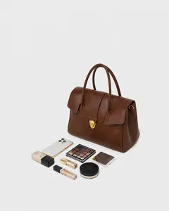 Macro detail of spacious brown leather tote showing interior capacity and golden buckle