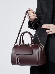 Elegant deep burgundy leather Boston handbag with tassel detail and adjustable shoulder strap