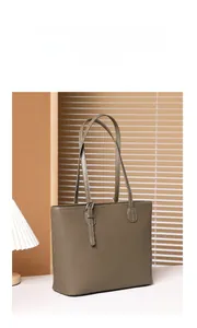 Close-up of taupe litchi grain leather tote bag with fine stitching and silver hardware