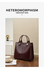 Elegante borsa tote in pelle bordeaux scuro su una scrivania con delle riviste