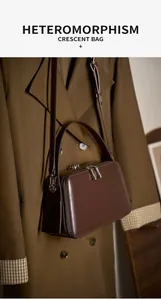 Detail view of dark brown leather crescent bag hanging on a matching trench coat