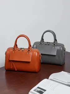 Classic leather Boston handbags in brown and grey with handles and front flap pocket