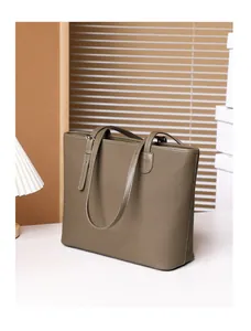 Detailed view of dark brown pebbled leather tote bag with elegant long shoulder straps