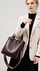 Dettaglio borsa tote in pelle bordeaux con tracolla jacquard retrò e piedini in metallo
