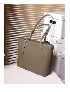 Close-up of olive green pebbled leather tote bag with stylish metal buckle adjustment