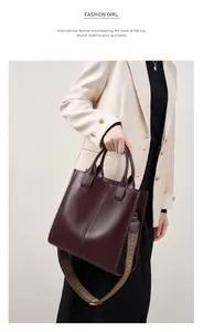 Dettaglio della borsa tote in pelle bordeaux con tracolla intrecciata geometrica su modella