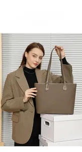 Close-up of a dark brown lychee texture leather tote bag with adjustable shoulder strap