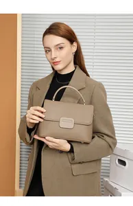 Close-up of pebble grain leather texture on a tan top-handle shell bag for women