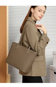 Detail of a brown lychee pattern leather tote bag with elegant white contrast stitching