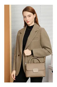 Chic khaki pebbled leather satchel bag on a model featuring a top handle and strap