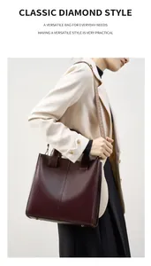 Dettaglio borsa tote in pelle bordeaux con trama fine e tracolla con motivo geometrico