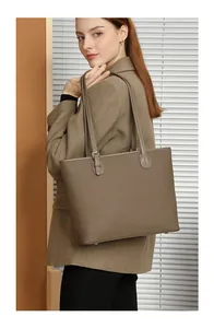 Detailed view of large tote bag featuring lychee grain texture and protective bottom studs
