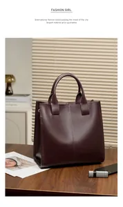 Dettaglio della borsa tote in pelle bordeaux con cuciture su legno scuro