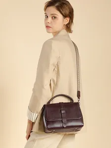 Dark burgundy leather handbag with vintage woven strap shown in an elegant side view