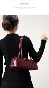 Dettaglio della borsa a spalla in pelle bordeaux indossata per look da ufficio