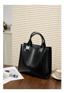Dettaglio della borsa tote in vera pelle nera con texture lucida e cucitura verticale